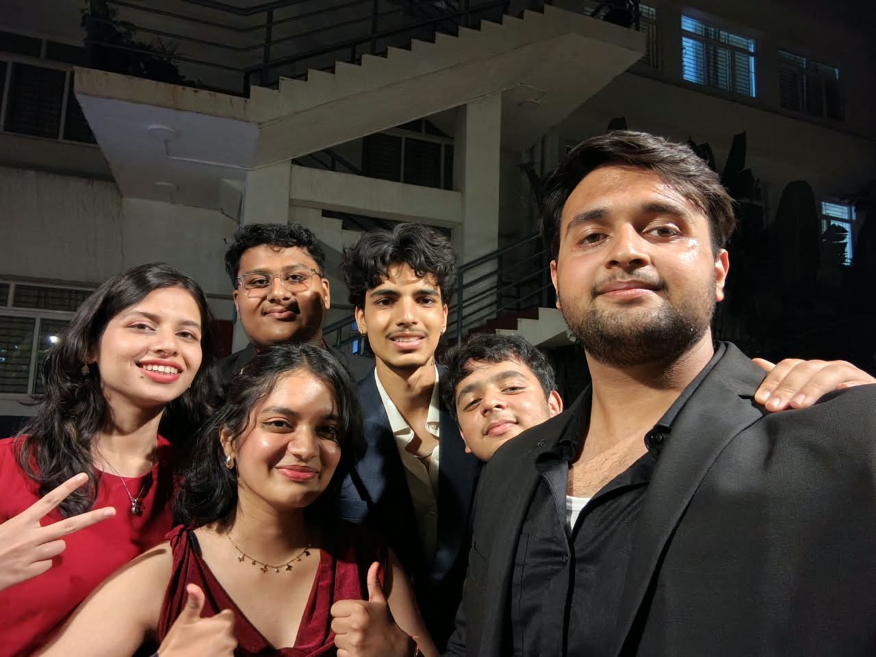 Six friends grinning at the camera under a stairwell